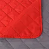 A close-up view of quilted fabric, showing a red quilted fabric overlapping a gray quilted fabric. Podgląd zdjęcia produktu
