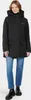 A woman wearing a black parka and blue jeans stands against a light gray background. Produktbild-Vorschau