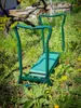 A green garden kneeler and seat is placed on the grass in a garden setting. Produktbild-Vorschau