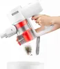 A hand is holding a white and red cordless vacuum cleaner, emptying dust into a white bowl. Produktbild-Vorschau