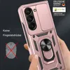 A hand is holding a rose gold phone case with a ring holder and camera cover. The background is dark. Produktbild-Vorschau
