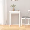 A white wooden dining table with a vase of greenery and a teacup on top, next to a white chair in a room with a white curtain and wooden floor. Produktbild-Vorschau