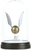 A golden snitch with silver wings displayed under a glass dome on a black base. Podgląd zdjęcia produktu