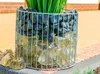 A close-up of a gabion planter filled with rocks and glass. Náhled obrázku produktu