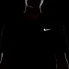 A close-up shot of a person wearing a black Nike t-shirt with a reflective silver Nike logo. Podgląd zdjęcia produktu