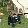 A camping scene with a tent, table, and a folding wagon filled with items. Produktbild-Vorschau