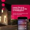 A house at night with lights on, and a smartphone displaying a smart home app. Produktbild-Vorschau