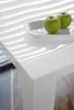 A close-up view of a white table with two green apples on a white plate. Produktbild-Vorschau