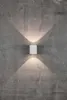A white cylindrical outdoor light fixture mounted on a textured gray concrete wall, casting light upwards and downwards. Anteprima dell’immagine prodotto