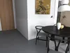 A dining set with chairs and a table in a room with a painting on the wall. Produktbild-Vorschau