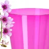 A close-up of a pink flower next to a pink pot. Anteprima dell’immagine prodotto