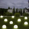 A garden at dusk with several illuminated spherical lights scattered across the lawn. Produktbild-Vorschau