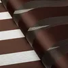 A close-up, angled view of a brown and white striped roller blind. Produktbild-Vorschau