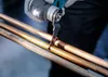 A person using a power tool to cut copper pipes. Anteprima dell’immagine prodotto