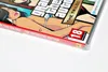 A close-up of the cover art for the Grand Theft Auto: The Trilogy – The Definitive Edition video game, showing stylized characters and the game's title. Produktbild-Vorschau