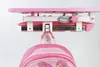 A close-up view of a pink backpack hanging from a pink desk attachment. Produktbild-Vorschau