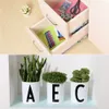 A collage showing a desk drawer with office supplies and three potted plants with letters on their pots. Produktbild-Vorschau