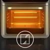 Close-up view of the interior of a toaster oven with heating elements illuminated, and a circular graphic overlay indicating a window. Produktbild-Vorschau