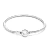 A silver Pandora bracelet with a central clasp is shown against a white background. Podgląd zdjęcia produktu