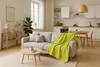 A living room and kitchen area with a sofa, coffee table, and kitchen counter. Produktbild-Vorschau