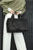 A person holding a black polka-dot duffel bag. Anteprima dell’immagine prodotto