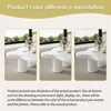 Three images of a white, irregularly shaped coffee table, with text describing color differences. Voir les images du produit