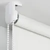 Close-up of a white roller blind mechanism and fabric attached to a white ceiling. Produktbild-Vorschau