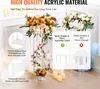 Two tall acrylic flower stands with floral arrangements, surrounded by decorative elements like candles and balloons, with text overlays highlighting product features. Voir les images du produit