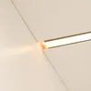 A close-up view of a white shelf with a recessed LED light strip emitting a warm yellow glow. Náhled obrázku produktu