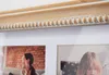 A close-up view of a wooden picture frame with decorative beading, showing two framed photographs. Podgląd zdjęcia produktu