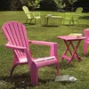 Several plastic chairs and tables are set up on a grassy lawn in a garden setting. Produktbild-Vorschau