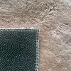 Close-up view of the back and edge of a beige rug, showing the stitching and the non-slip backing. Anteprima dell’immagine prodotto
