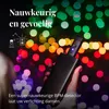 A hand holding a black Twinkly Music Dongle in front of a bokeh background of colorful lights. Náhled obrázku produktu