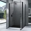 A modern bathroom with a black framed glass shower enclosure, featuring a rainfall shower head and handheld shower wand. The shower is set against a textured gray concrete wall, with a large window overlooking a mountain landscape. Produktbild-Vorschau