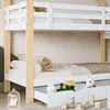 A close-up view of a white and wood bunk bed with drawers underneath, featuring children's toys. Náhled obrázku produktu