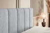 A close-up view of a bed's headboard and a bedside lamp. Produktbild-Vorschau
