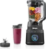 A Ninja blender with various ingredients in the pitcher, a smoothie in a cup, and a blade attachment, all set against a white background. Produktbild-Vorschau