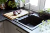 A kitchen sink area with a cutting board and radicchio on it, next to a faucet and plants. Anteprima dell’immagine prodotto