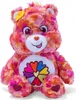 A plush toy bear with a colorful tie-dye pattern and a flower symbol on its chest. Anteprima dell’immagine prodotto
