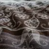A close-up view of a brown and white patterned fabric, likely bedding, showing the texture and design. Produktbild-Vorschau