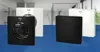 Two ventilation fans, one white and one black, are displayed against a blurred background of a modern bathroom. Voir les images du produit