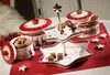 A festive display of Christmas-themed tableware, including tiered serving stands and lidded canisters, filled with cookies and chocolates. Náhľad obrázku produktu