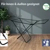 A black foldable drying rack is shown in a room with a gray wall and wooden floor. There are plants in pots on the left side of the image. In the bottom left corner, there are two inset images showing details of the drying rack's locking mechanism. In the  Produktbild-Vorschau