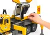A close-up shot of a toy crane truck with a hand interacting with a control panel. Náhľad obrázku produktu