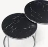 Two nesting round coffee tables with a black marble-like top and silver legs. Voir les images du produit