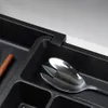 A close-up view of a cutlery organizer in a drawer, with a spoon visible. Produktbild-Vorschau