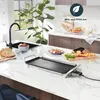 A modern kitchen counter with an electric grill, sink, faucet, and various food items. Voir les images du produit
