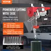 A red electric hoist is shown suspended from a beam, with a car in the background. Text overlays describe its lifting capacity, height, and speed. Náhľad obrázku produktu