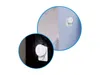 Two close-up views of a white LED night light plugged into a wall socket, one against a dark patterned wallpaper and the other against a light-colored wall. Produktbild-Vorschau