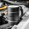 A black mug shaped like stacked tires sits on a car engine. Voir les images du produit